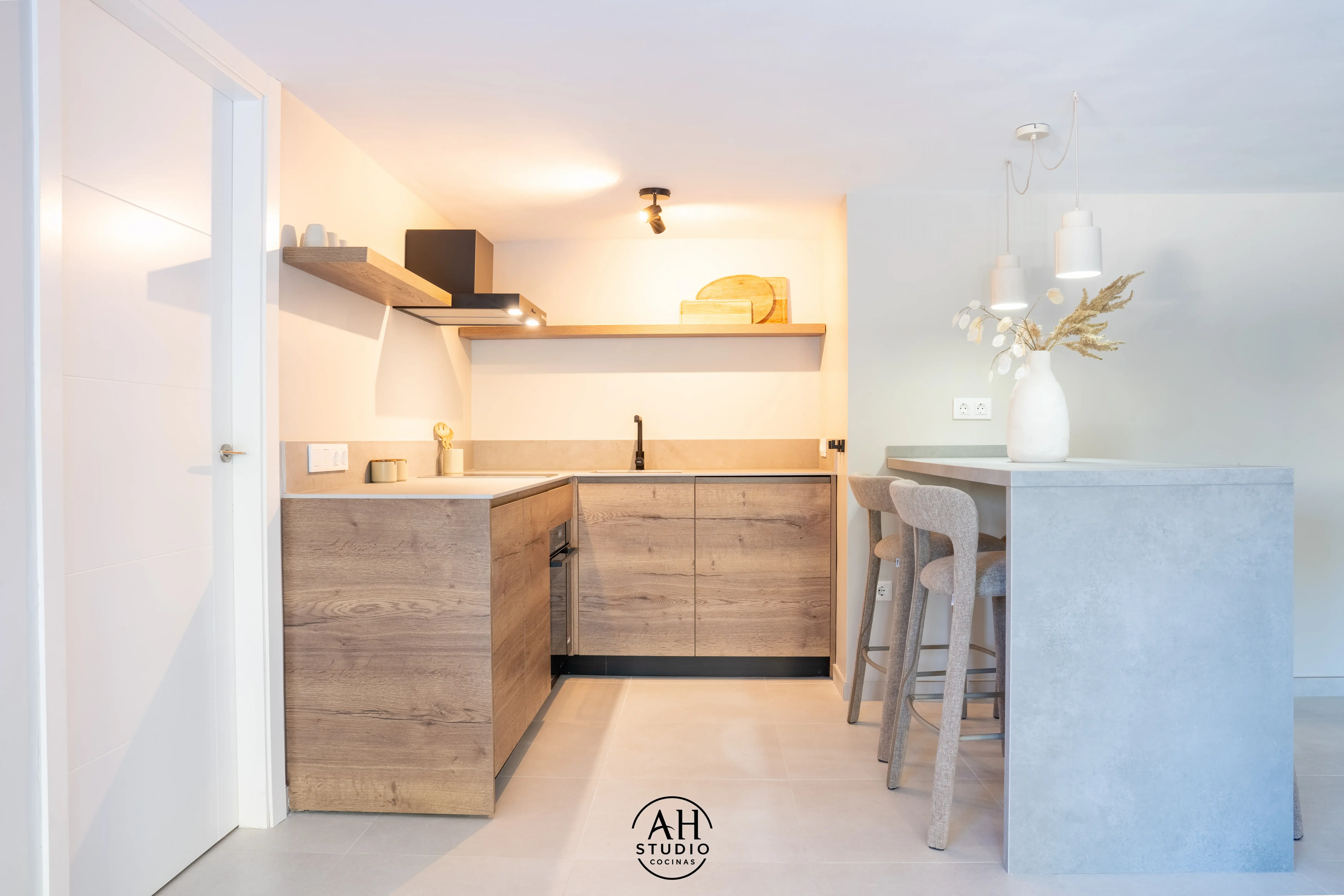 Cocina en L de roble con barra de cemento y taburetes